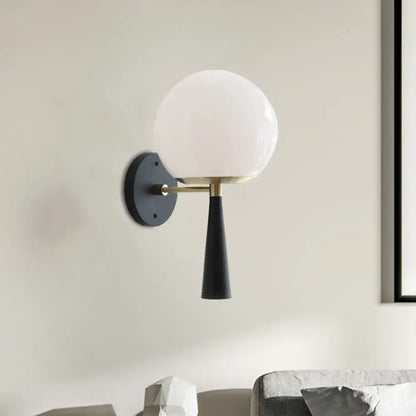 Black Globe Compact Wall Sconce with white glass globe and brass arm on Tampa Home & Garden Store