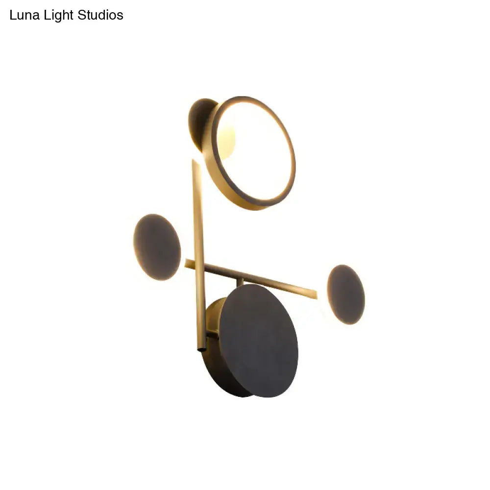 Black metallic wall sconce with brass finish and circular ring light with geometric discs on Tampa Home & Garden Store