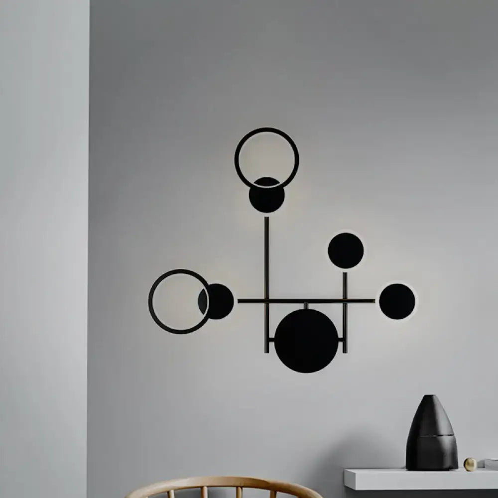Black metallic wall sconce by Decorbites with geometric circle design and intersecting rods on Tampa Home & Garden Store