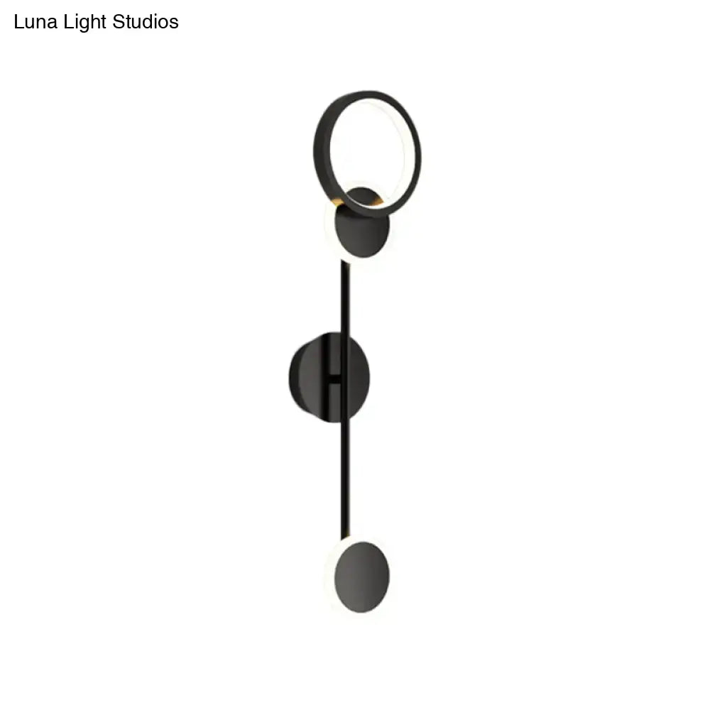 Black metallic wall sconce with circular ring, vertical stem, and disk accents by Decorbites on Tampa Home & Garden Store