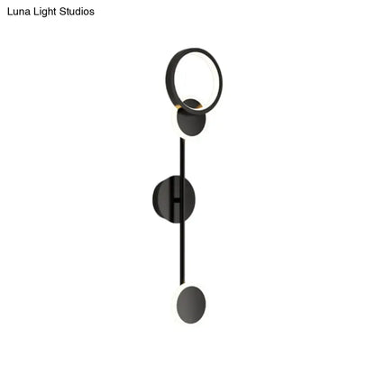 Black metallic wall sconce with circular ring, vertical stem, and disk accents by Decorbites on Tampa Home & Garden Store