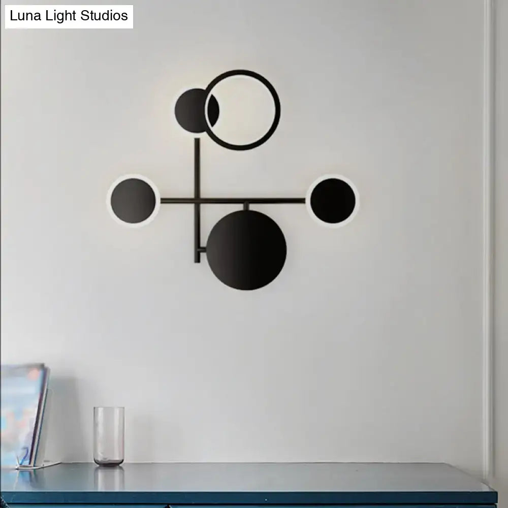 Black metallic wall sconce by Decorbites with connected black circles on a white wall on Tampa Home & Garden Store