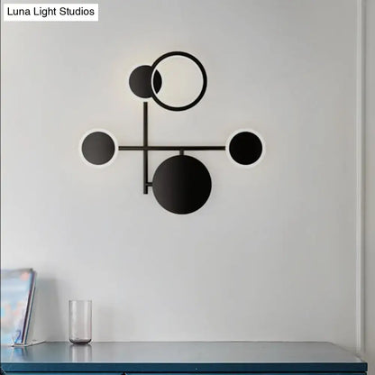 Black metallic wall sconce by Decorbites with connected black circles on a white wall on Tampa Home & Garden Store