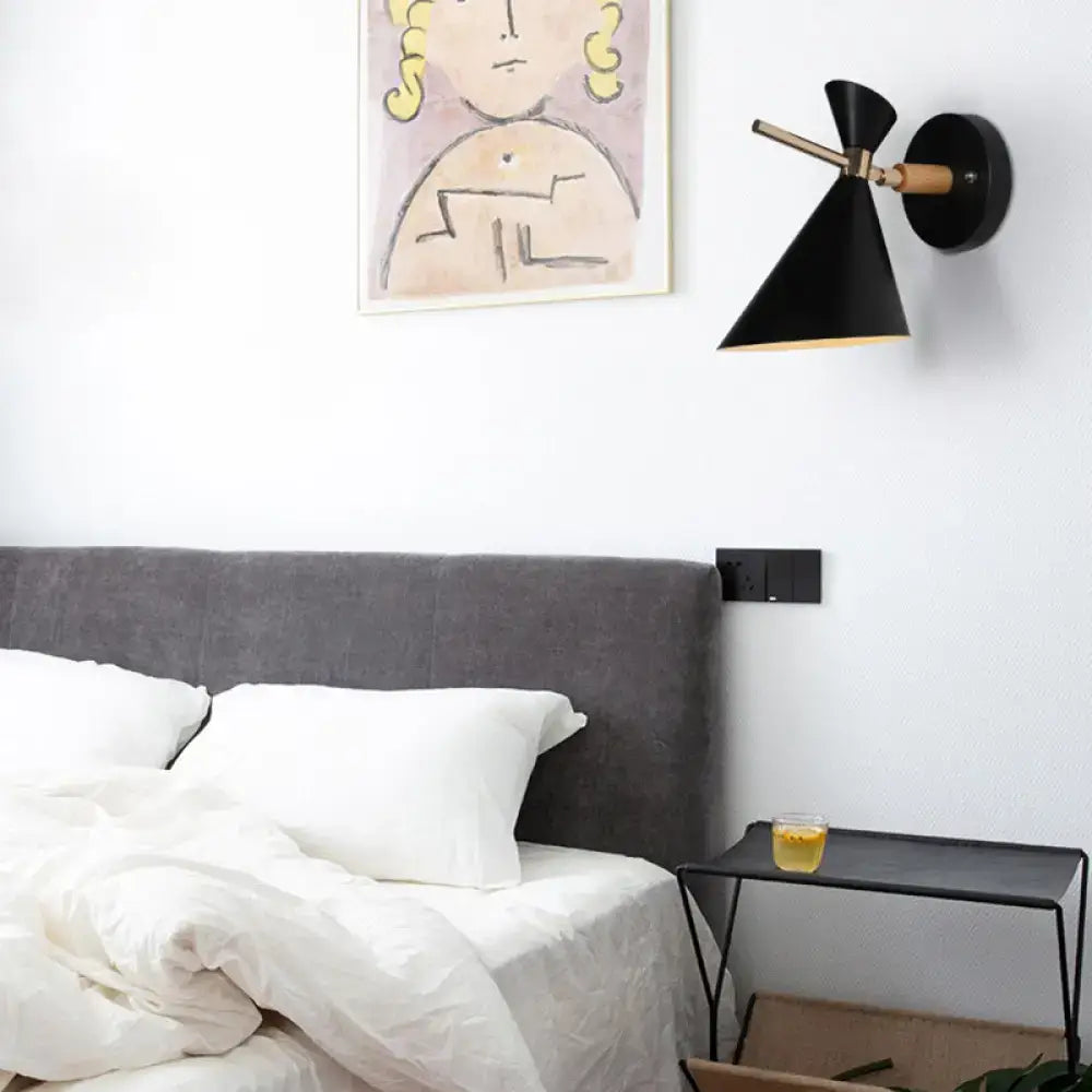 Black angle wall sconce with wooden arm and conical shade above bed on Tampa Home & Garden Store
