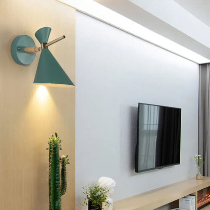 Black angle wall sconce with teal cone shade and brass hardware mounted on wood panel on Tampa Home & Garden Store