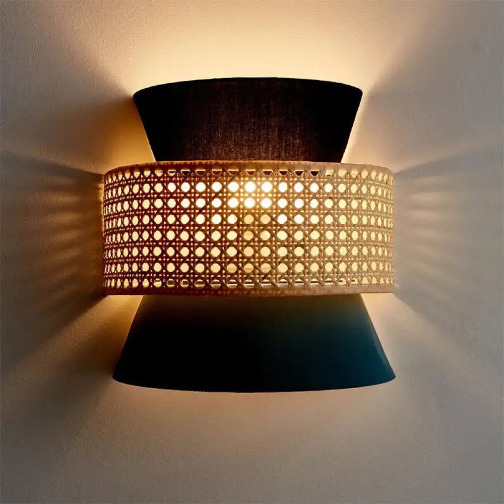 Blue rattan wall sconce with woven band and black tapered backplates, emits warm light on Tampa Home & Garden Store