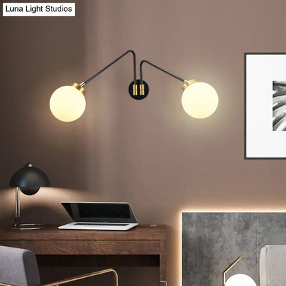 Black milk glass wall lamp with dual globe bulbs and brass accents on Tampa Home & Garden Store