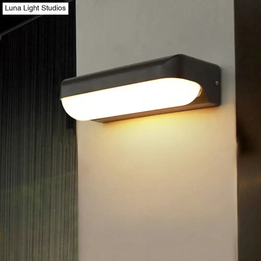 Black capsule flush mount wall sconce, black metal housing, warm white LED glow on Tampa Home & Garden Store