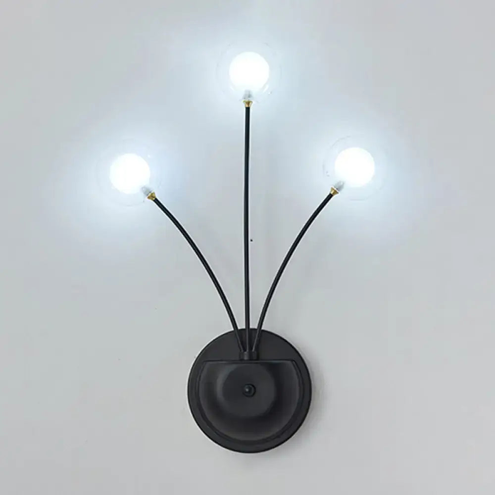 Black iron globe sconce with three curved arms and lit bulbs by Decorbites on Tampa Home & Garden Store