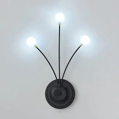 Black iron globe sconce with three curved arms and lit bulbs by Decorbites on Tampa Home & Garden Store