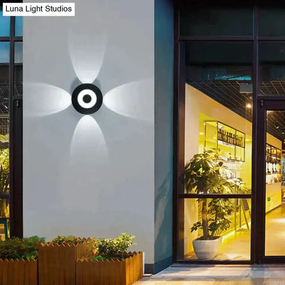 Modern black circular LED outdoor wall sconce Decorbites with petal light pattern on wall on Tampa Home & Garden Store