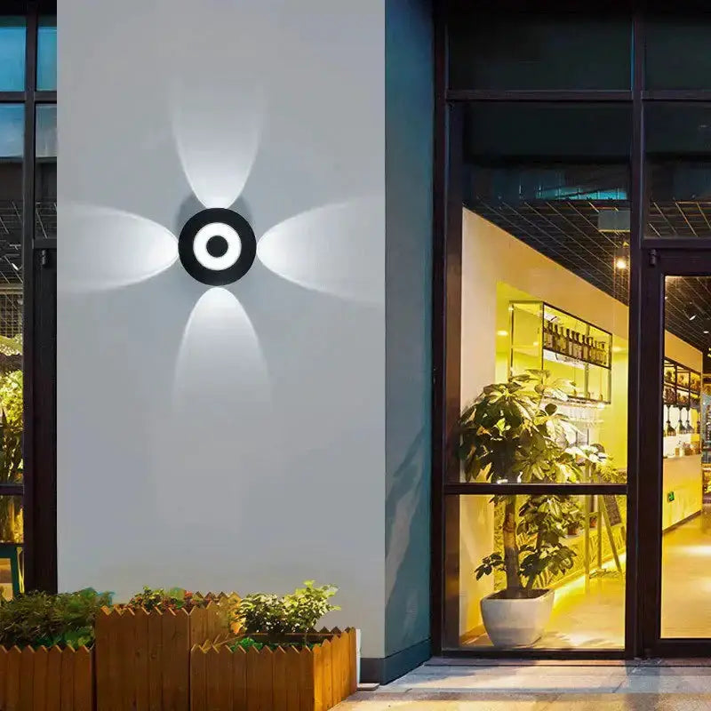 Modern black circular LED outdoor wall sconce with four petal-shaped light arcs on Tampa Home & Garden Store