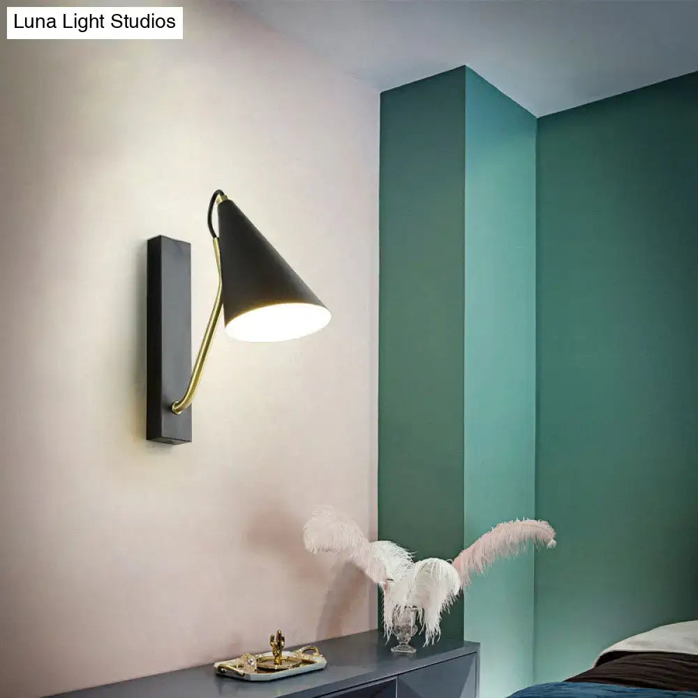Black cone wall sconce with brass curved arm by Decorbites on light wall on Tampa Home & Garden Store