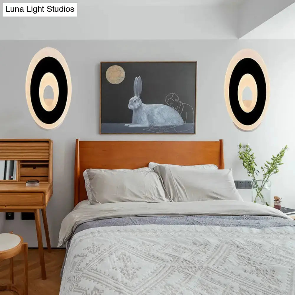 Modern black and cream oval LED wall lamp pair flanking bed in gray bedroom Decorbites on Tampa Home & Garden Store