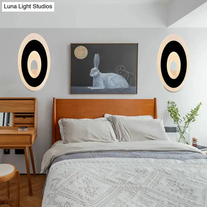 Modern black and cream oval LED wall lamp pair flanking bed in gray bedroom Decorbites on Tampa Home & Garden Store