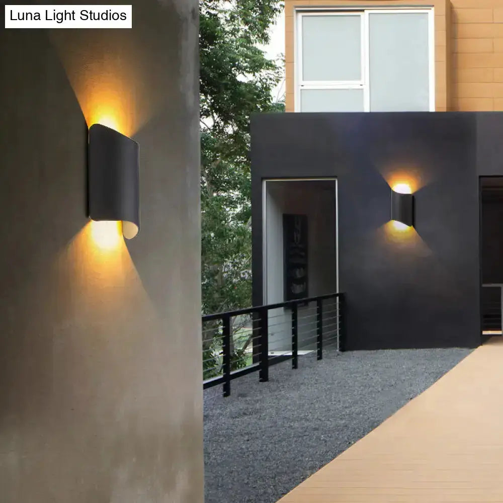 Modern black curved LED outdoor wall lamp for yard; two sleek wall lights on dark exterior walls on Tampa Home & Garden Store