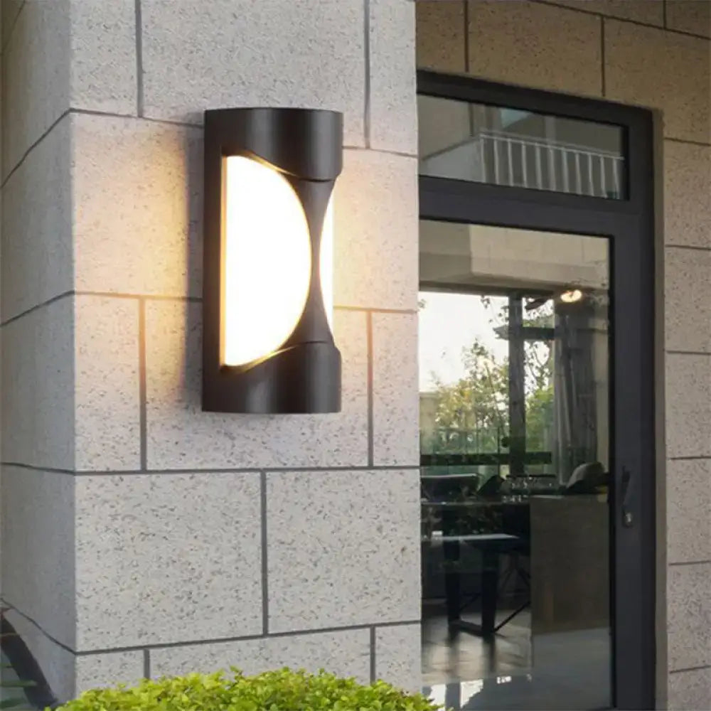 Black curved patio sconce outdoor wall light by Decorbites mounted on beige stone wall on Tampa Home & Garden Store