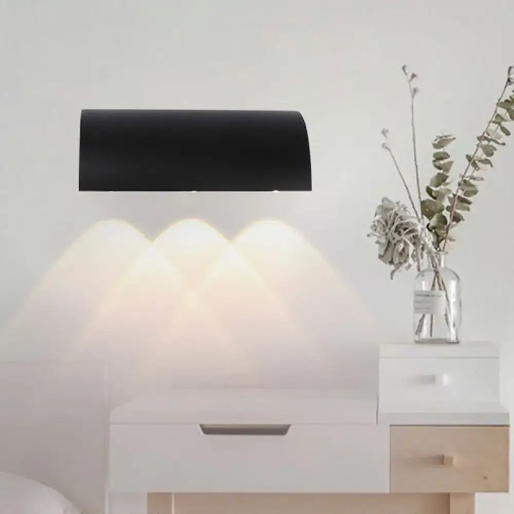 Black curved outdoor lamp by Decorbites, metal shade casting soft glow over a dresser with vase on Tampa Home & Garden Store