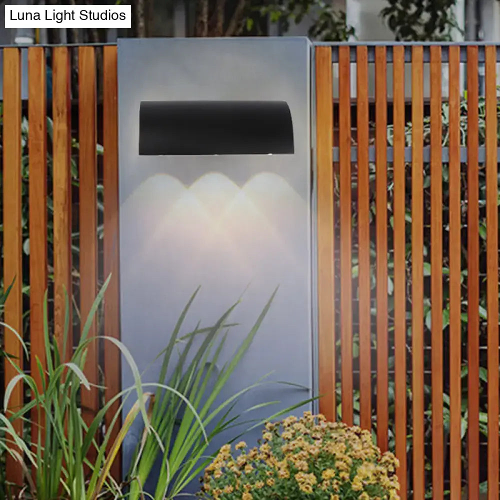 Black Curved Outdoor Lamp by Decorbites, mounted on a panel with warm downlight arches on Tampa Home & Garden Store