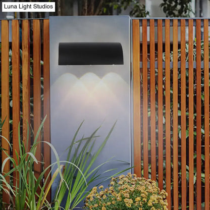 Black Curved Outdoor Lamp by Decorbites, mounted on a panel with warm downlight arches on Tampa Home & Garden Store