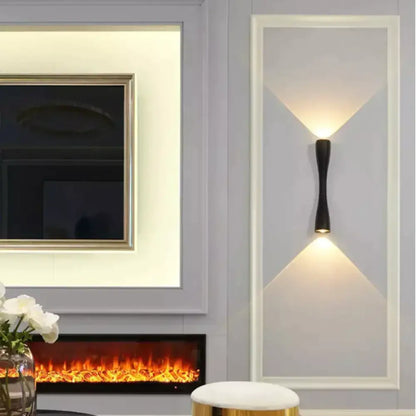 Black curved IP65 outdoor wall sconce on a light gray wall panel, dual up/down warm light on Tampa Home & Garden Store