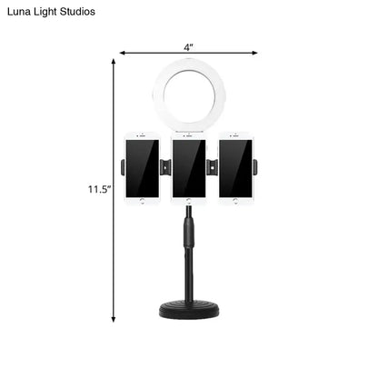 Black Ring Wall Light with white halo ring on a tripod holding three smartphones on Tampa Home & Garden Store