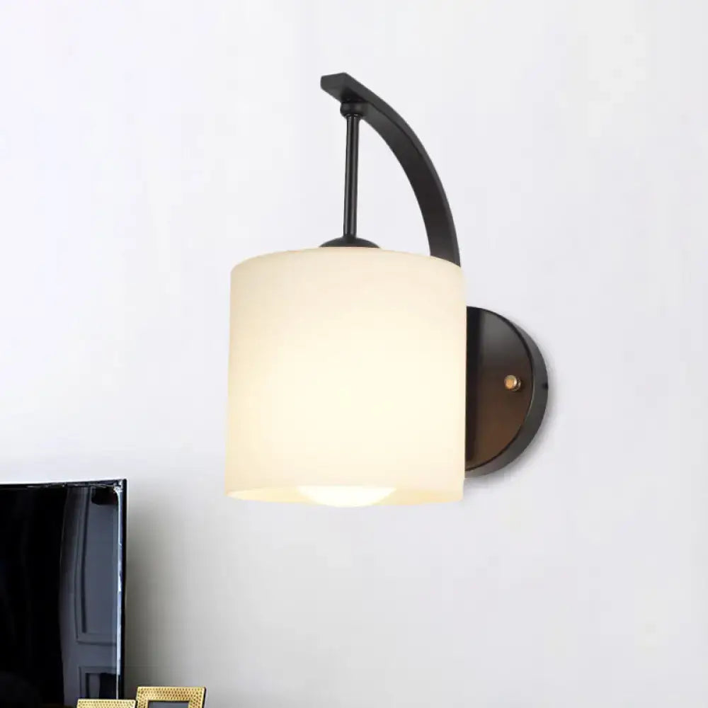 Black cylindrical opal glass wall sconce by Decorbites with curved metal arm on Tampa Home & Garden Store
