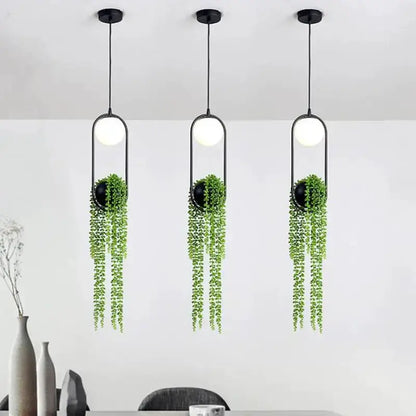 Three modern black flower pot pendant lights with trailing greenery planters for dining room on Tampa Home & Garden Store