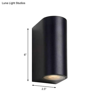 Black metal outdoor patio wall sconce, cylindrical housing with downward light on Tampa Home & Garden Store