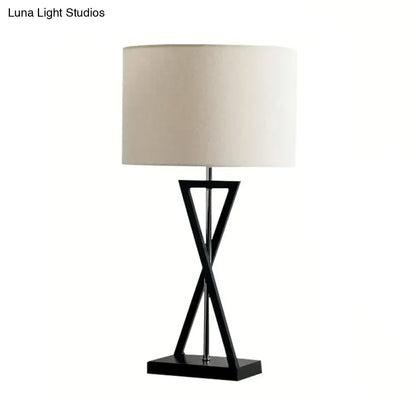 Black Nightstand Drum Lamp with an X-shaped black metal base and beige fabric shade on Tampa Home & Garden Store