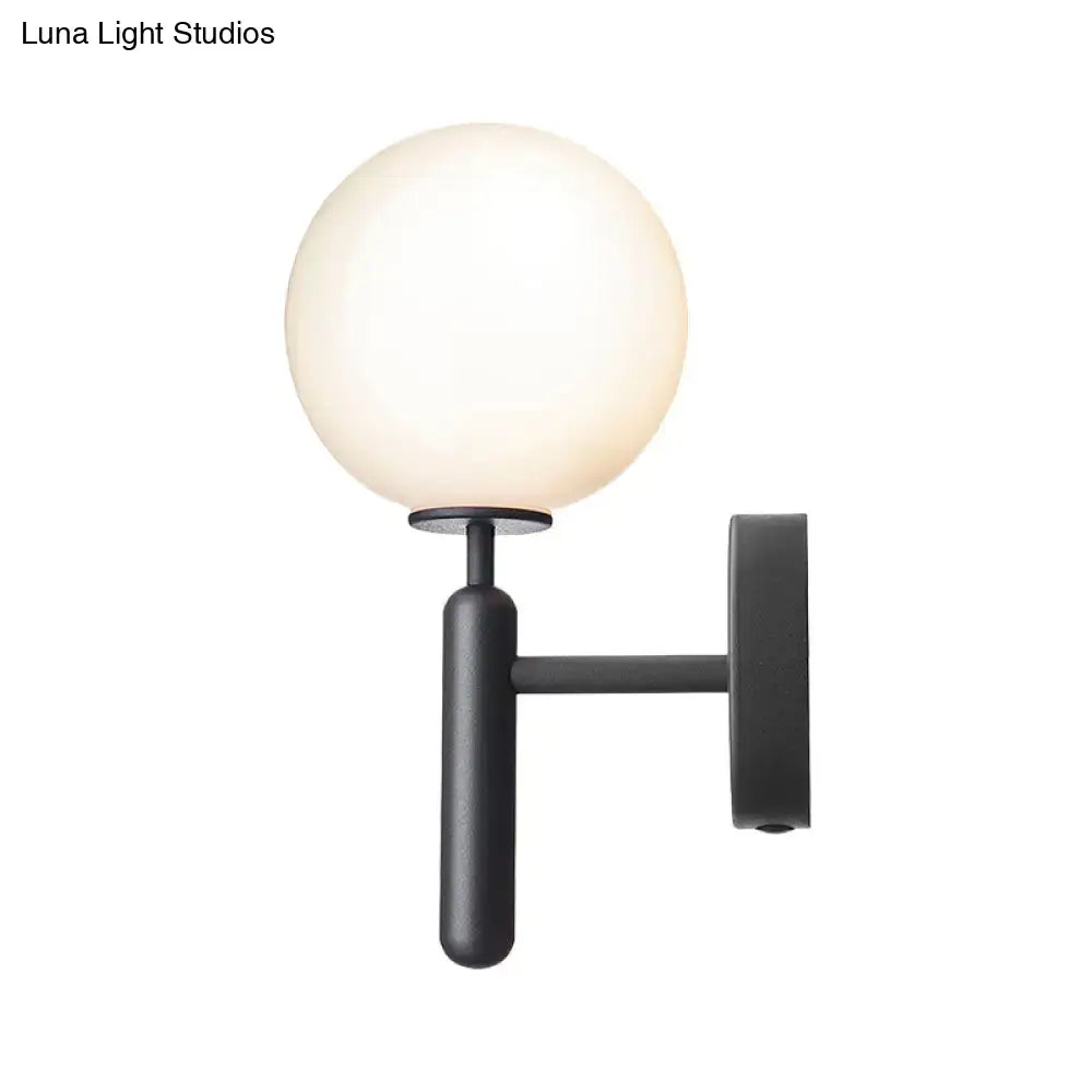 Black glass globe wall lamp by Decorbites with frosted sphere on black metal arm on Tampa Home & Garden Store