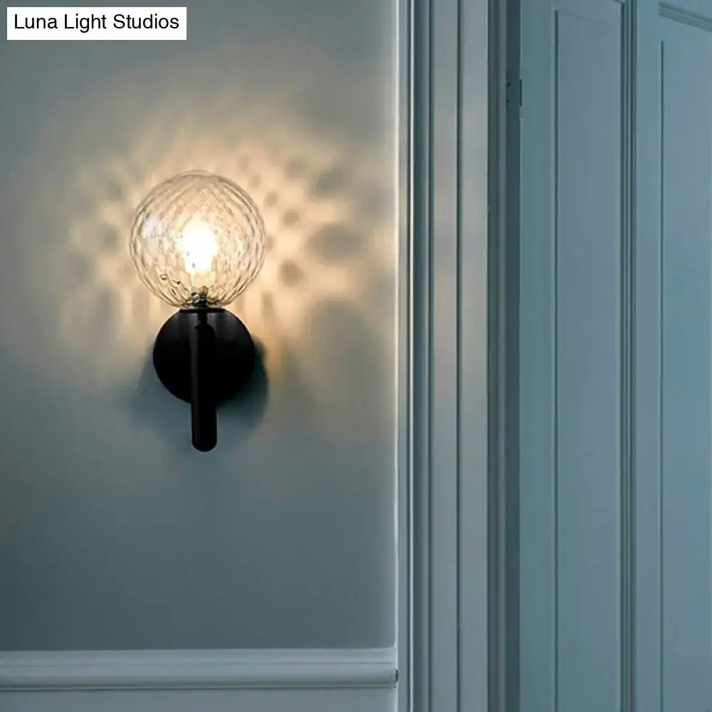 Black glass globe wall sconce with textured orb and black mount on Tampa Home & Garden Store