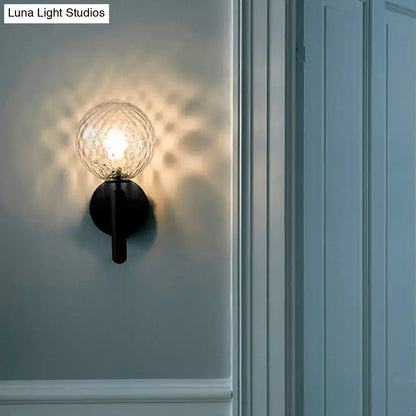 Black glass globe wall sconce with textured orb and black mount on Tampa Home & Garden Store