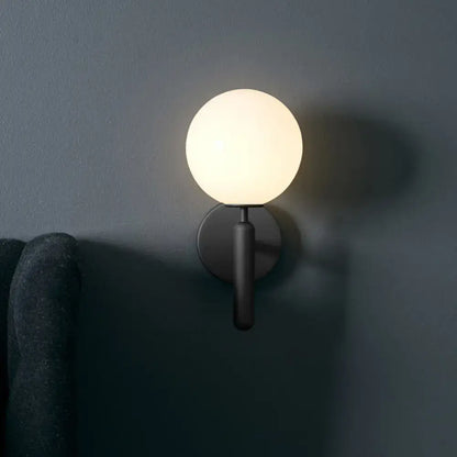 Black glass globe wall lamp with frosted orb shade and matte black mounting plate on Tampa Home & Garden Store