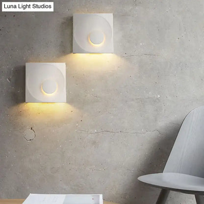 Cement Nordic wall sconces, square blocks with circular recess, warm light on concrete wall on Tampa Home & Garden Store