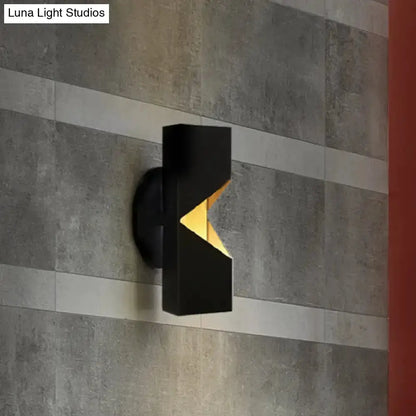 Modern black and gold geometric LED wall sconce with iron shade on gray textured wall on Tampa Home & Garden Store