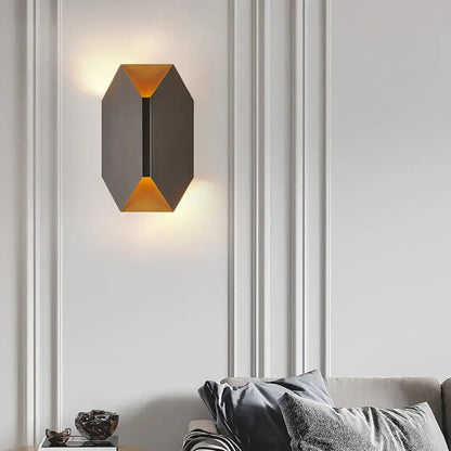 Black metal geometric wall lamp Decorbites, gold-tone accents, emits warm amber light on Tampa Home & Garden Store