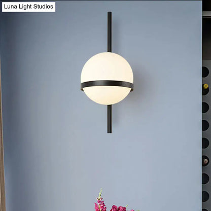 Black Gold Glass Sconce with frosted globe and black metal band on a vertical rod on Tampa Home & Garden Store