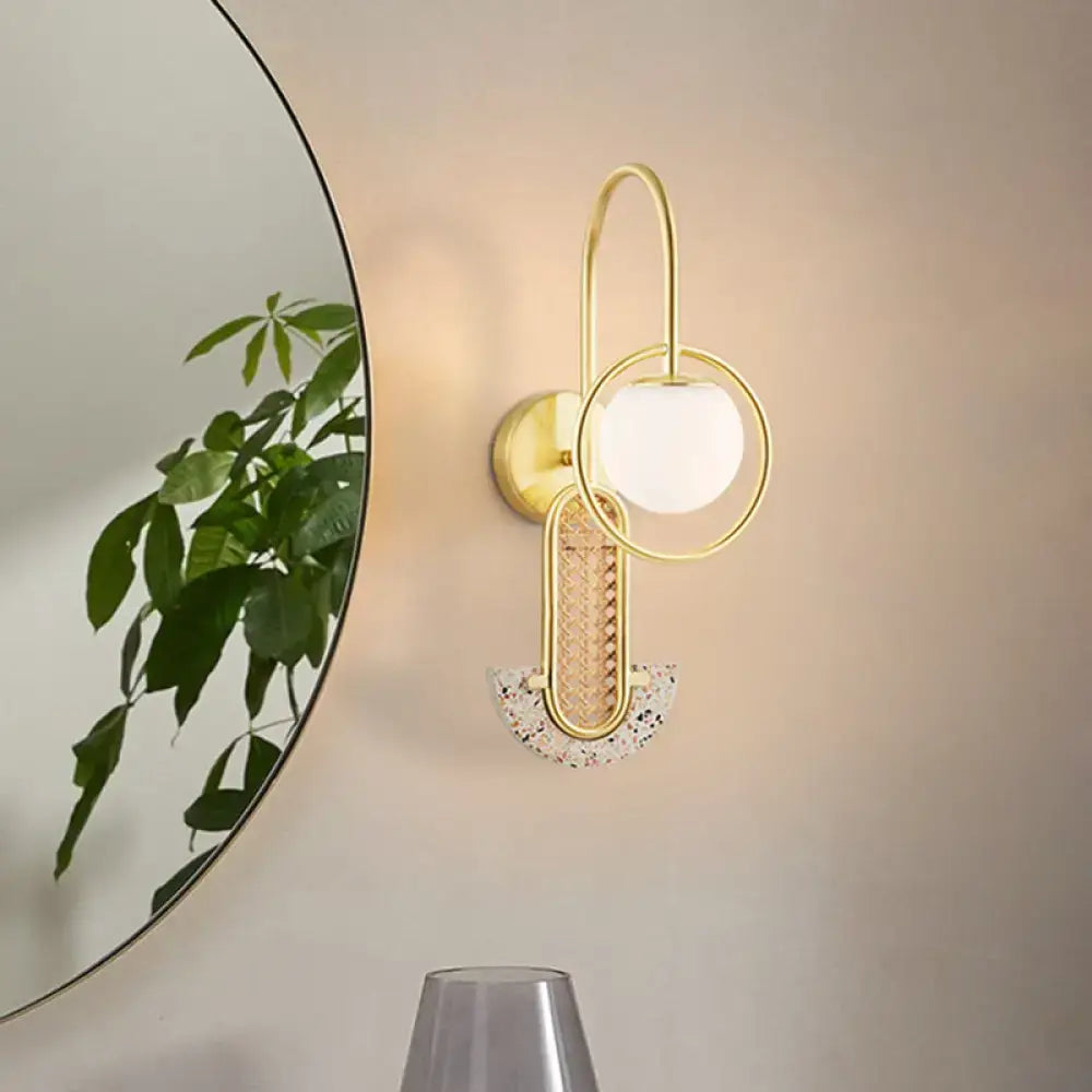 Gold opal glass wall sconce with looping rings and speckled semicircle accent on wall on Tampa Home & Garden Store