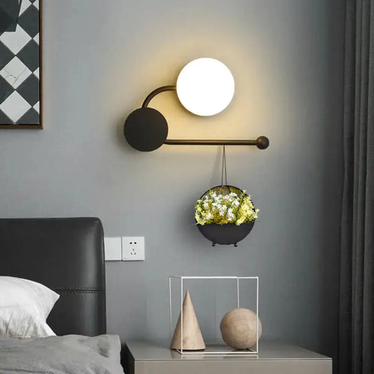 Modern black planter sconce with hanging flower pot and white globe light on Tampa Home & Garden Store