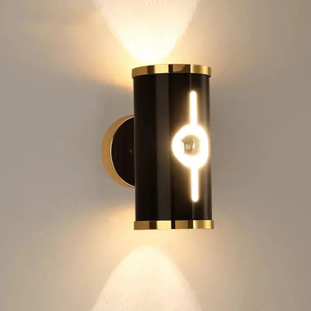 Black vertical wall sconce Decorbites with gold trim and warm LED filament lighting on Tampa Home & Garden Store