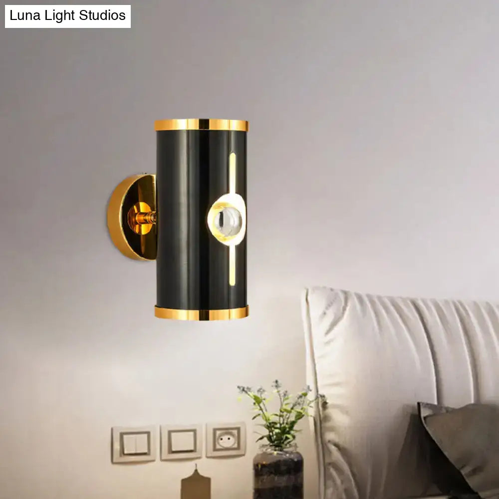 Black vertical wall sconce with gold trim and circular LED accent by Decorbites on Tampa Home & Garden Store
