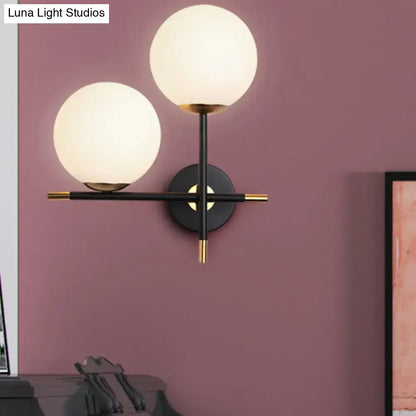 Black milky glass double-globe wall sconce by Decorbites with brass accents on Tampa Home & Garden Store