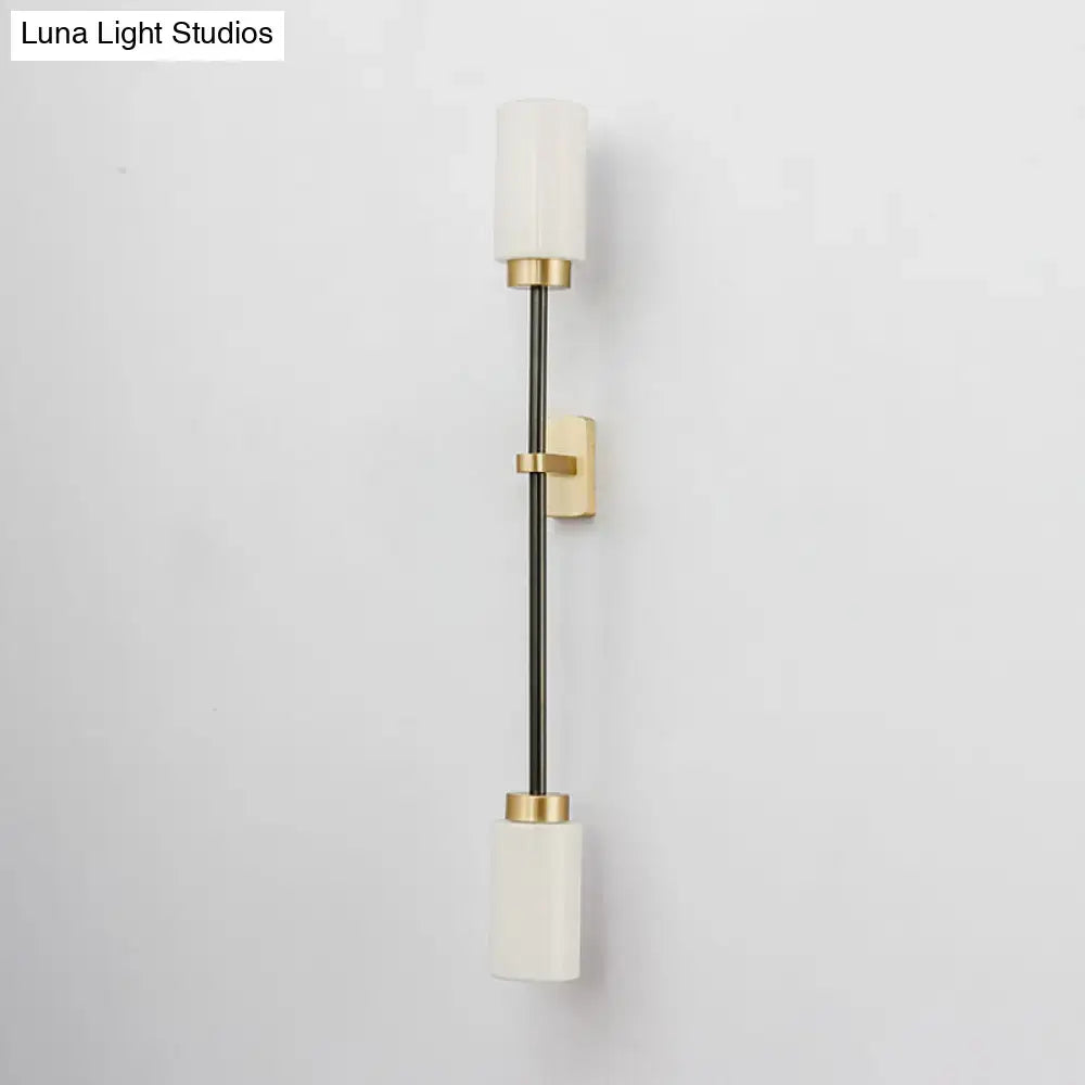 Gold glass wall sconce dual-head with white shades on a slim black stem and gold mounts on Tampa Home & Garden Store