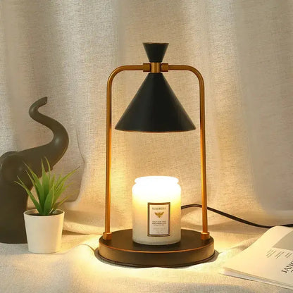 Modern black and gold candle warmer lamp with cone shade on a slim frame, warm candle glow on Tampa Home & Garden Store