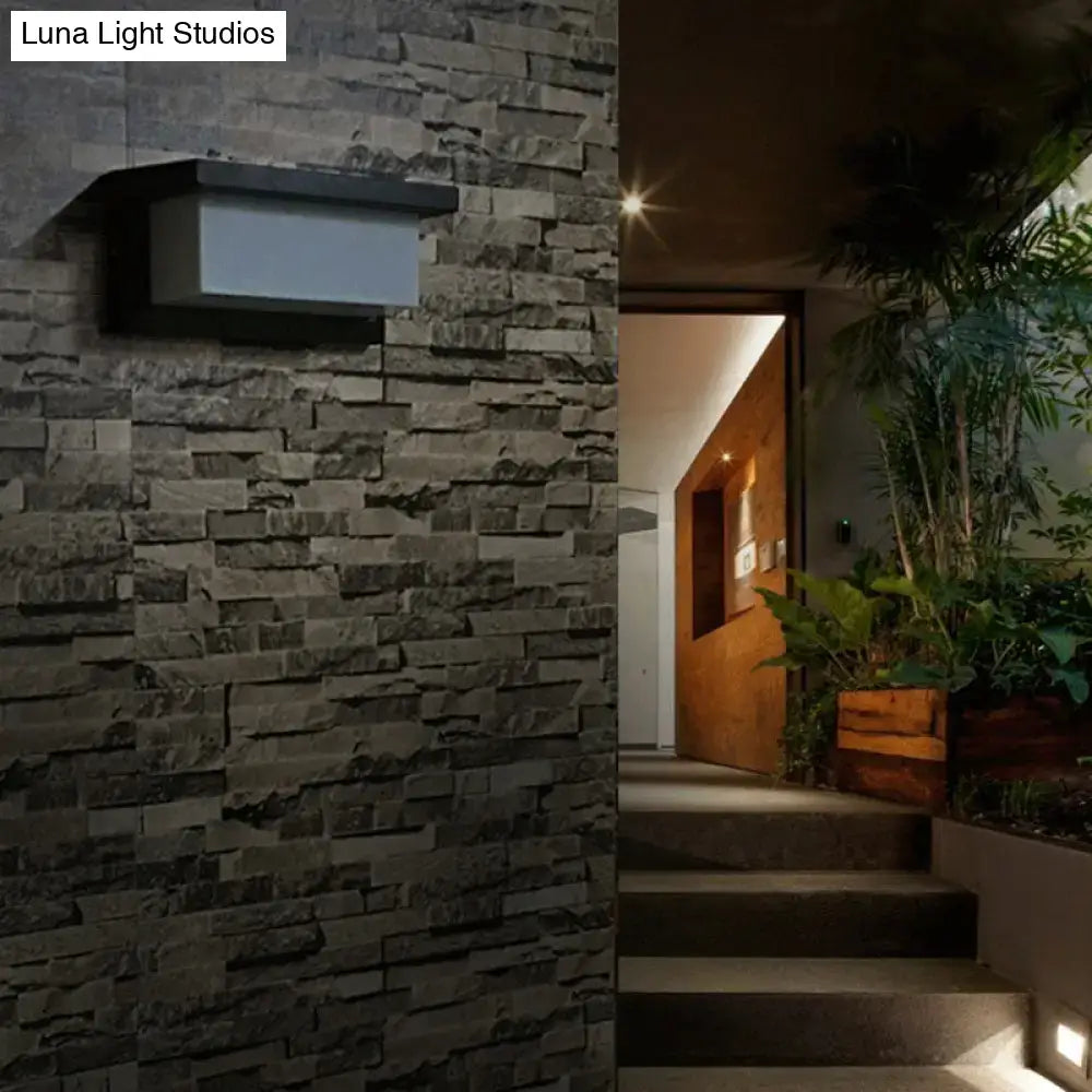 Black rectangle outdoor wall light in black metal mounted on a stone wall near a modern entry on Tampa Home & Garden Store