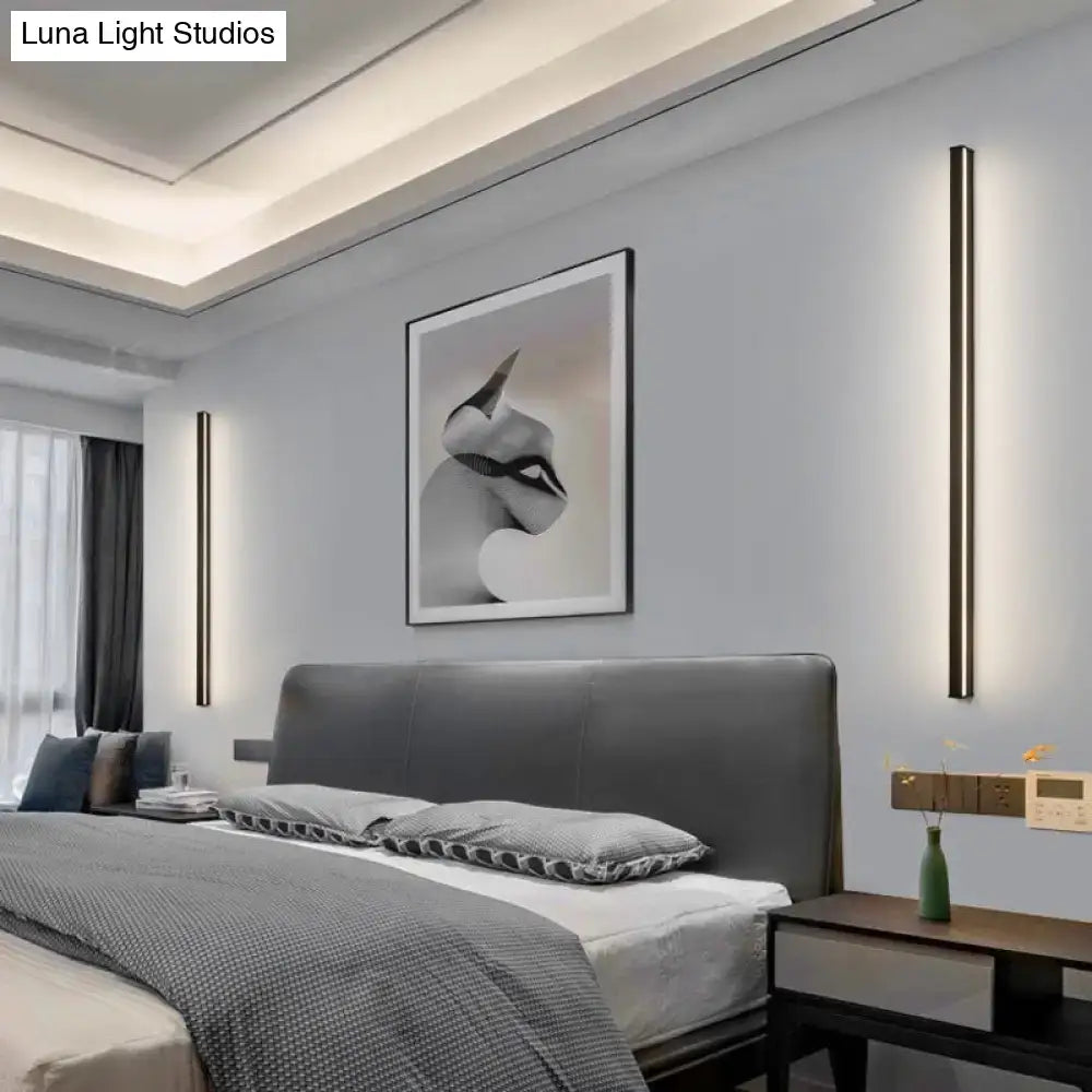 Modern black linear flush mount wall sconces pair flanking a bed in a modern bedroom on Tampa Home & Garden Store