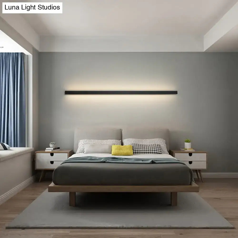 Decorbites modern black linear flush mount wall sconce above bed with warm ambient glow on Tampa Home & Garden Store