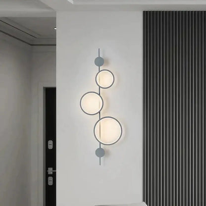 Black long wall sconce with stacked illuminated circular rings on a vertical bar Decorbites wall light on Tampa Home & Garden Store