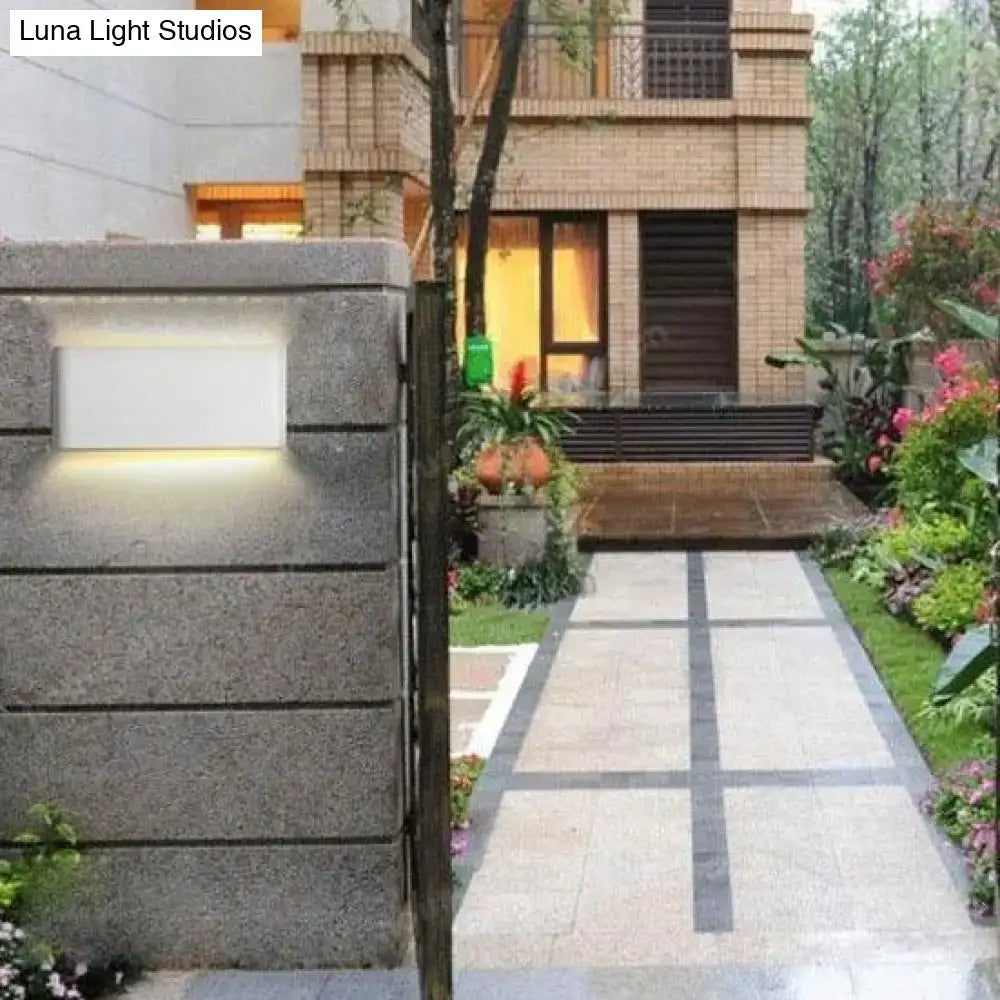 Decorbites Black Outdoor Wall Light mounted on a gray stone pillar by a modern home entry on Tampa Home & Garden Store